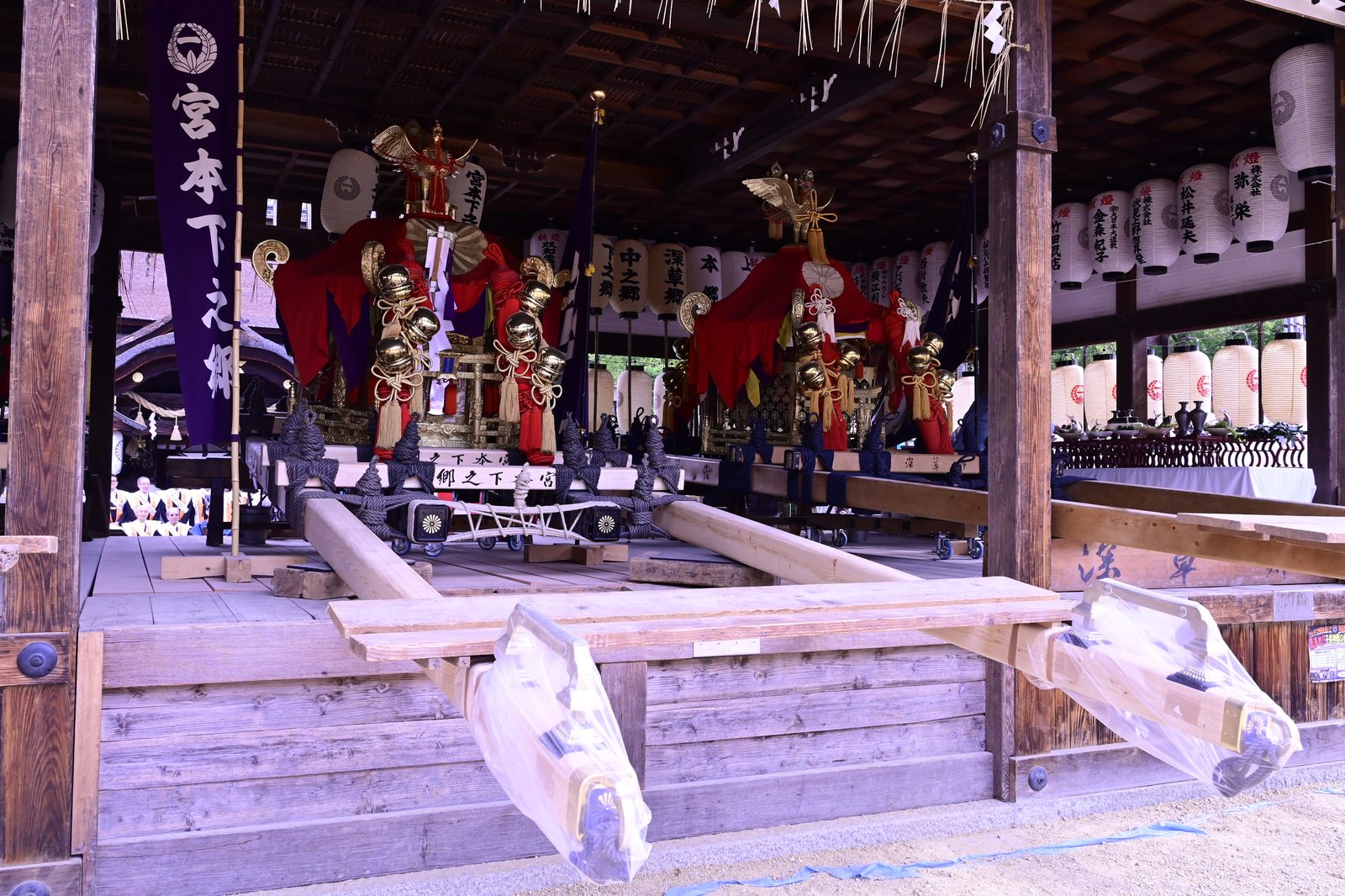 神社の祭礼用の木製担ぎ棒が並ぶ風景